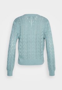 Suéter de punto azul claro con un diseño texturizado en forma de rejilla abierta, mangas largas y un dobladillo acanalado. La parte trasera presenta un patrón similar.