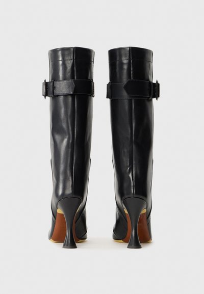 Black leather knee-high boots with a tapered heel, rectangular buckle accents, and a smooth texture; minimal seams and sleek silhouette.