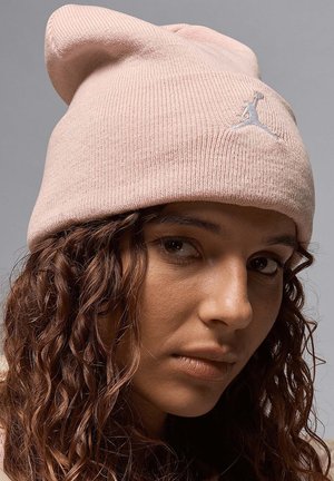 Berretto di maglia rosa con una texture morbida e risvolto. Presenta un logo Jumpman ricamato bianco sulla parte anteriore.