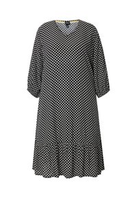 Schwarzes Kleid mit V-Ausschnitt, 3/4 Ärmeln und einem ausgestellten Saum. Hat ein weißes Herzmuster auf der gesamten Fläche. Hergestellt aus weichem Stoff.