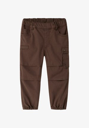 Brązowe dziecięce spodnie cargo z elastycznym paskiem w talii, przednimi kieszeniami, boczną kieszenią z klapką, szwami na kolanach oraz elastycznymi mankietami przy kostkach.