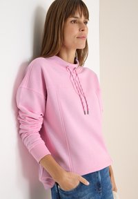 Lichtroze sweatshirt met een hoge kraag, trekkoorddetail en geribde manchetten, met een relaxte pasvorm en een zachte textuur.