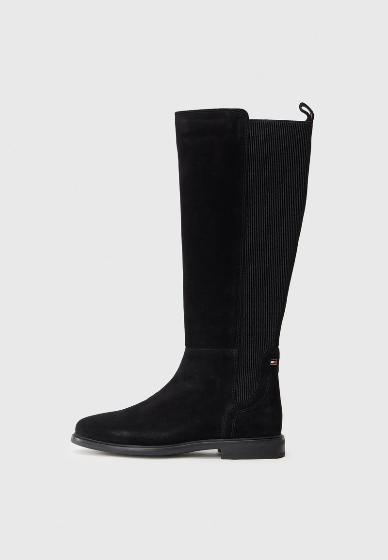 Bottes en suède noir hautes avec une finition lisse, un panneau en tissu côtelé et un petit accent logo près de la cheville. Semelle en caoutchouc plate.