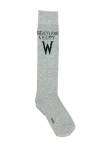 Calcetín gris hasta la rodilla con el texto "HEARTLESS & HAPPY" y un logo de "W". Material de punto suave, textura lisa y detalle de puño acanalado.