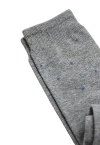 Calcetines de algodón grises con un puño acanalado, que presentan una base gris sólida y pequeños puntos de lunares azul marino en toda la superficie.