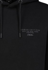 Black hooded sweatshirt in cotton blend, featuring front-print text "URBAN EDITION ONLY THE REAL ONES SUBLEVEL." Thick drawstrings and ribbed cuffs.