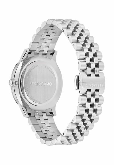 Roostevaba terasest kell, millel on poleeritud pind, link-randmevärv, ümmargune korpus ja graveeritud brändi nimi taga. Omab safiirkristallit.