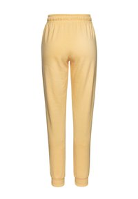 Gelbe Jogginghose aus weichem Stoff, mit elastischem Bund, tapering Beinen und Rippenbündchen am Knöchel. Einfaches Design und einfarbig.