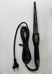 Krulstaaf met een zwarte, taps toelopende cilinder en een textuurgrip. Lange zwarte stroomdraad met een twee-pins stekker. Vlakke ondergrond eronder.