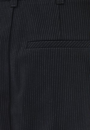 Czarne spodnie w prążki wykonane z teksturowanej tkaniny, z tylną kieszenią w wzór zygzakowaty. Subtelne niebieskie paski w całej tkaninie.