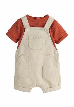 Beige cotton toddler overalls with front pockets over a rust-colored short-sleeve shirt featuring subtle palm tree patterns.