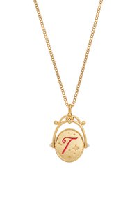 Gouden ketting met een ronde hanger met een rode letter "T", decoratieve accenten en kleine pareldetails aan de zijkanten. De ketting heeft een textuur.