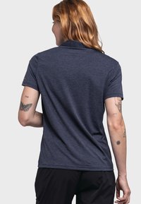 Marineblaues Polohemd mit kurzen Ärmeln und Kragen. Weicher, strukturierter Stoff mit lockerer Passform und geradem Saum hinten.