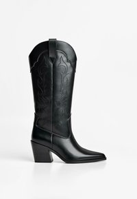 Black leather cowboy boots with a pointed toe, featuring intricate stitching patterns and a mid-heel design. Smooth texture.