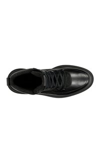 Stivale alla caviglia in pelle nera con punta rotonda, fodera in tessuto, lacci neri e cuciture decorative. Suola spessa con leggera scanalatura.