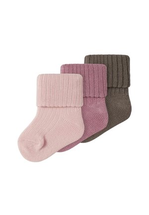Drei dicke gestrickte Babysocken in blassem Rosa, staubigem Rosa und Braun, jeweils mit umgeschlagenem Bündchen, überlappend auf weißem Hintergrund angeordnet.