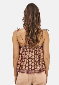 Top de tanque con estampado, tirantes ajustables, cintura elastizada y un diseño que presenta motivos florales en tonos de naranja y marrón.