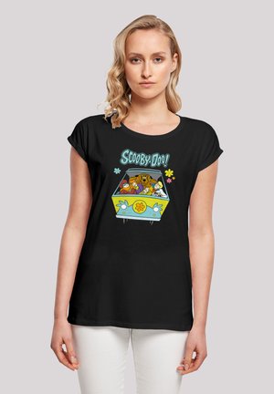 Svart t-skjorte med et fargerikt "Scooby-Doo!"-motiv som viser karakterene i en van, accentuert av blomster og lekne skrifttyper.