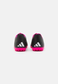 Scarpe da ginnastica nere con suole rosa, caratterizzate da una tomaia testurizzata, accenti del logo bianchi e battistrada multidirezionale sulla suola.