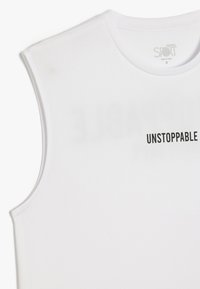 Witte mouwloze sporttanktop van lichtgewicht stof, met het woord "UNSTOPPABLE" in zwarte letters op de voorkant.
