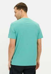 Kortærmet t-shirt i lys teal, lavet af blødt bomuld. Har en klassisk rund hals og et lige snit. Ingen synlige mønstre.