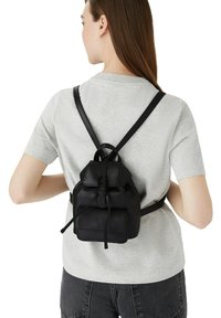 Zaino in pelle nera con apertura superiore a coulisse, spallacci regolabili e tasca frontale. Il materiale appare liscio con una texture leggermente lucida.