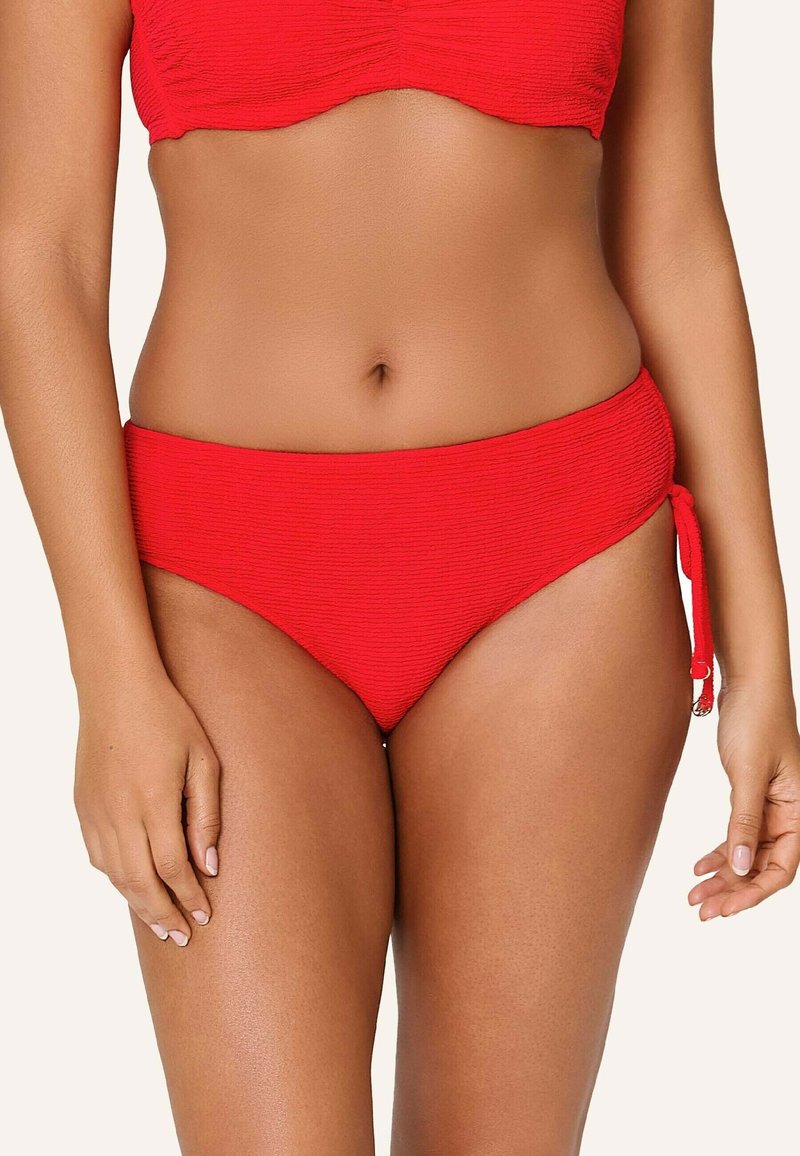 Červené bikiny s vysokým pasem, které mají strukturovanou tkaninu a nastavitelná boční zavazování pro dokonalé padnutí. Hladký povrch a jasná barva.