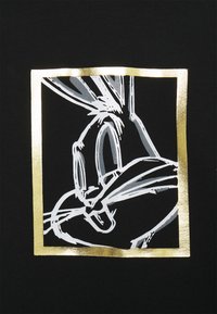 Stylizovaný bílý a šedý obrys tváře Bugs Bunnyho uvnitř lesklého zlatého čtvercového rámu na černém pozadí.