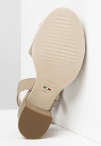 Beige Sandalensohle mit einem strukturierten Muster, ausgestattet mit einem braunen Gummihighheel und geprägten Markendetails, gekennzeichnet mit "NeroGiardini" und Größe 37.