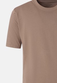 Lyhythihainen, vaaleanruskea puuvillapaita pyöreällä kaula-aukkolla, esitetty vartalon osassa, merkitty koossa suuri ja brändinä Casa Moda.