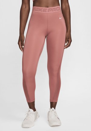 Nike Pro tajice u prašnjavo ružičastoj boji s visokim strukom i perforiranim logom, izrađene od glatkog, rastezljivog materijala s prilagođenim dizajnom.