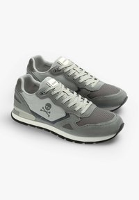 Graue Sneakers aus einer Mischung von Wildleder und Netzmaterialien, mit runder Zehenpartie, Schnürsenkeln und einem Totenkopf-Graphic an der Seite. Detaillierte Nähte setzen Akzente.