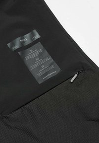 Zwarte performance jacket van waterafstotend en winddicht materiaal. Voorzien van een gestructureerde stof, ritsluiting en waslabels aan de binnenkant.