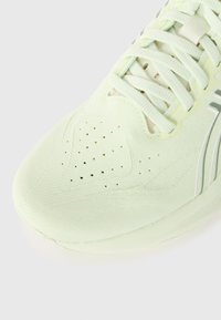 Light green athletic shoe with a textured mesh upper, perforations for breathability, flat laces, and a white accent stripe on the side.