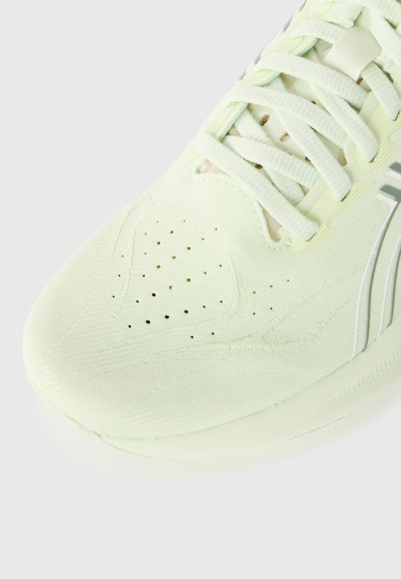 Light green athletic shoe with a textured fabric upper, perforations for breathability, and white accents on the sides and laces.