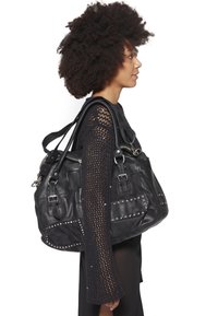 Černá kožená kabelka se stříbrnými nýty, několika kapsami a dvojitými ramenními popruhy, zobrazena na bílém pozadí.