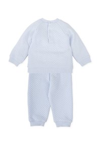 Conjunto de dos piezas en azul claro, hecho de un tejido texturizado, que presenta un cuello redondo, mangas raglán y pantalones con cintura elástica y puños.