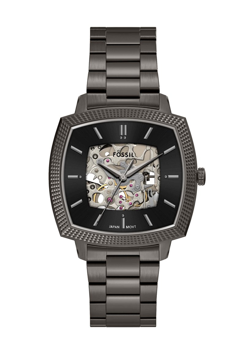 Montre mécanique carrée avec un bracelet en acier inoxydable, cadran noir et boîtier transparent révélant des mouvements complexes et des accents roses.