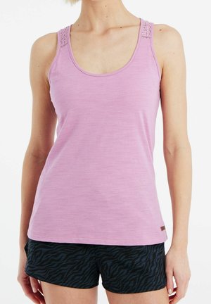 Jasnoróżowy top na ramiączkach wykonany z miękkiego materiału, z ozdobnymi paskami. W zestawie z czarnymi szortami w print zebry.