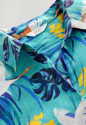 Linnen shirt in turquoise met een tropisch bloemenpatroon; bevat blauwe bladeren, oranje accenten en een klassiek kraagontwerp.