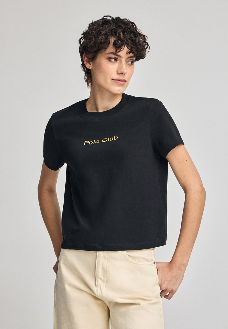 Svart kortärmad t-shirt i bomull med rund halsringning och guldtexten "Polo Club" broderad på framsidan.