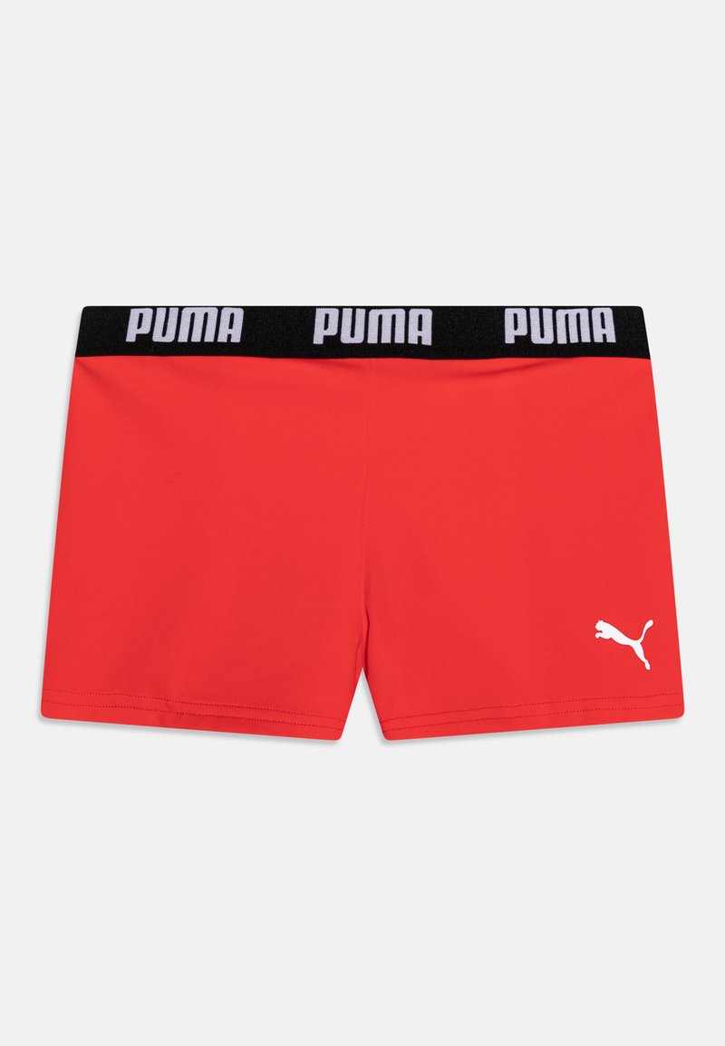 Červené športové šortky s čiernym pásom, ktorý obsahuje biele logo "PUMA"; biele logo na ľavej strane. Hladká, elastická tkanina.