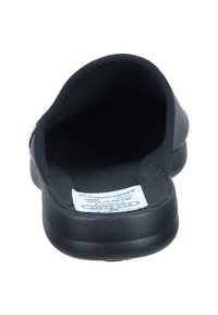 Mørkegrå slip-on sko med blødt stofinteriør, rund tå, struktureret sort sål og label med information om komfort og materiale.