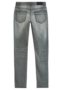 Jeans de mezclilla gris con un corte ajustado. Presentan dos bolsillos traseros con costuras decorativas y un sutil desvanecimiento a lo largo de las piernas.