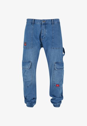 Denim cargo pants with a relaxed fit, featuring large side pockets, elastic cuffs, and a red and black logo patch on the front.