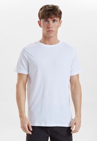 Hvid bomulds T-shirt med en klassisk rund halsudskæring og korte ærmer, der har en glat tekstur og lige snit. Ingen mønstre eller detaljer.