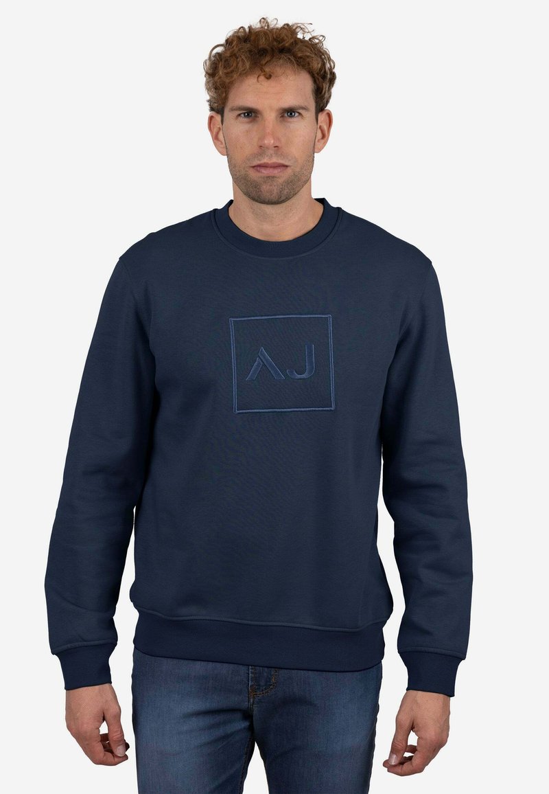 Sudadera azul marino hecha de tela suave, con un logo cuadrado con diseño "AJ" en un azul ligeramente más claro, puños y dobladillo acanalados.