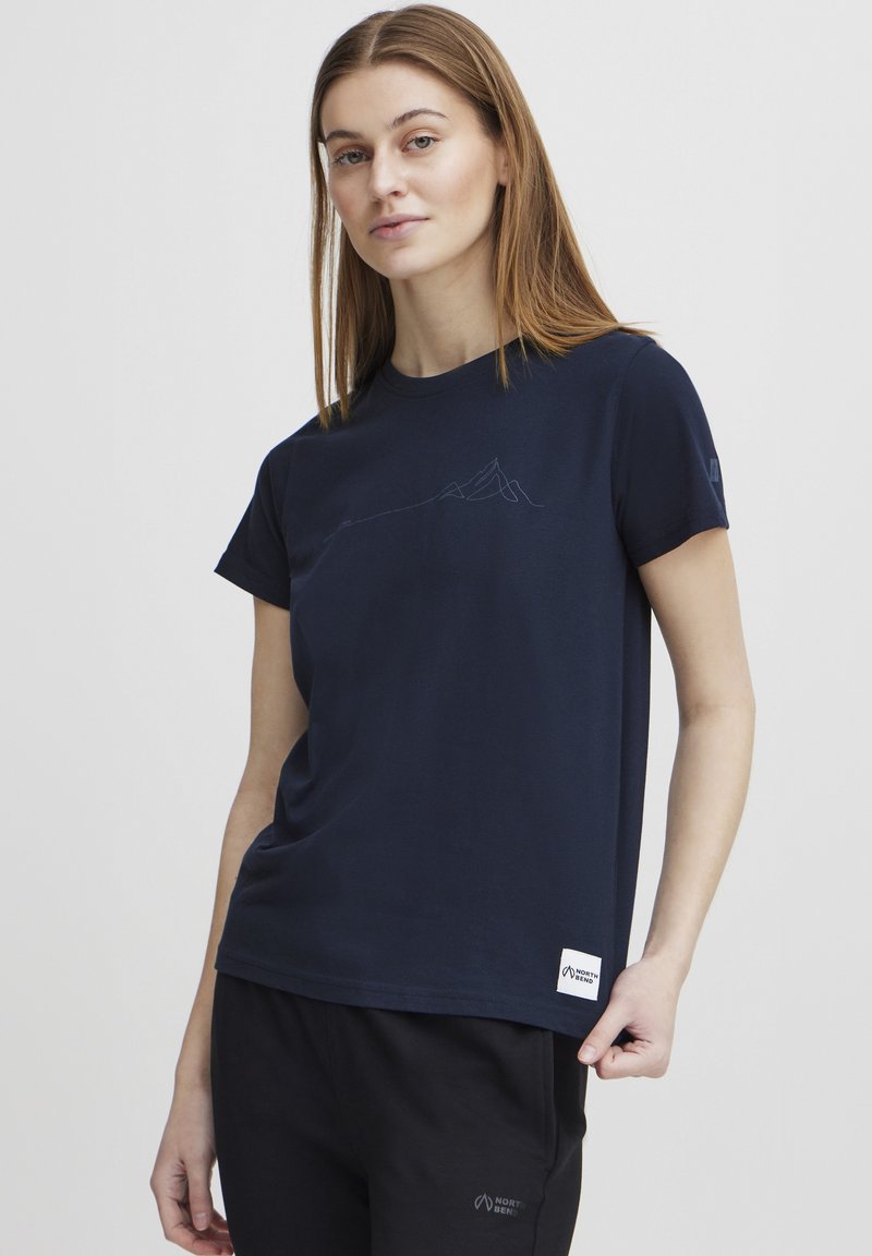 Camiseta de algodón azul marino con mangas cortas, que presenta un diseño minimalista de montaña en azul claro y una etiqueta de la marca en el dobladillo.