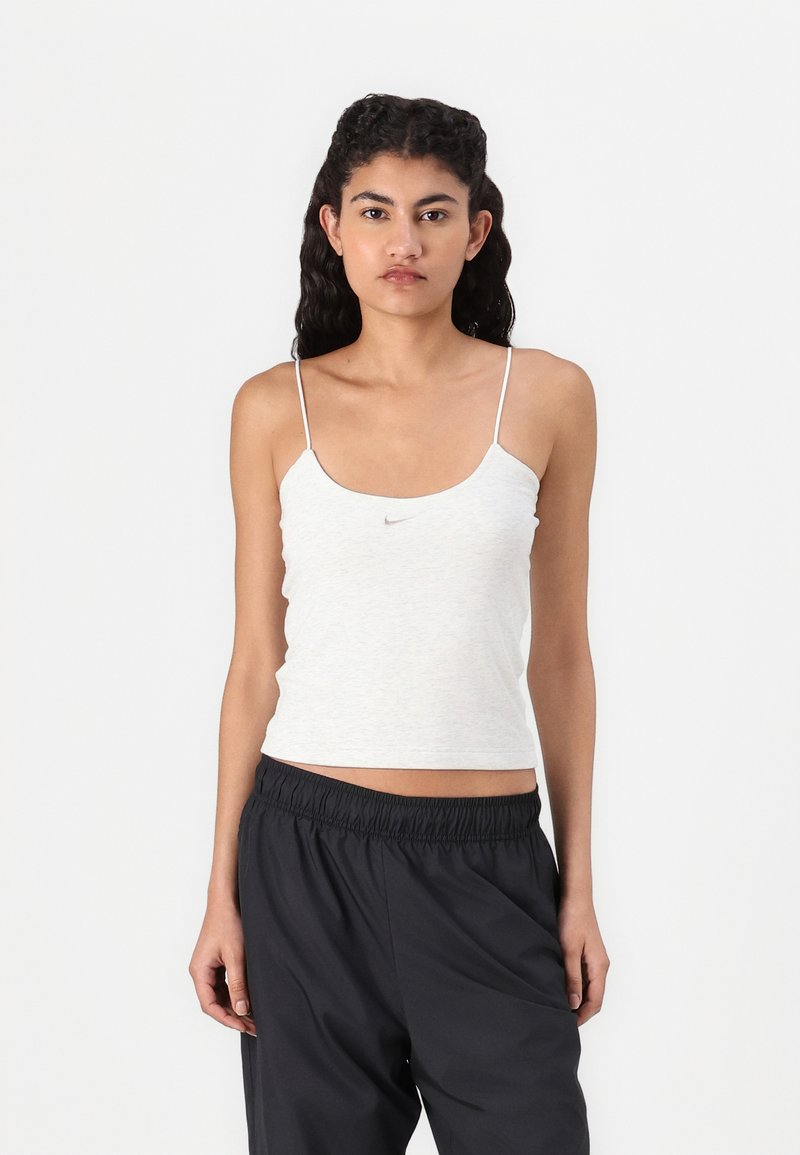 Camisola sem mangas de cor cinza claro com alças finas tipo spaghetti e um pequeno logótipo da Nike no peito, textura suave e um design ajustado.