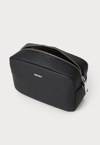 Black faux leather cosmetic bag with a rectangular shape, silver zipper closure, and embossed logo detailing on the front.